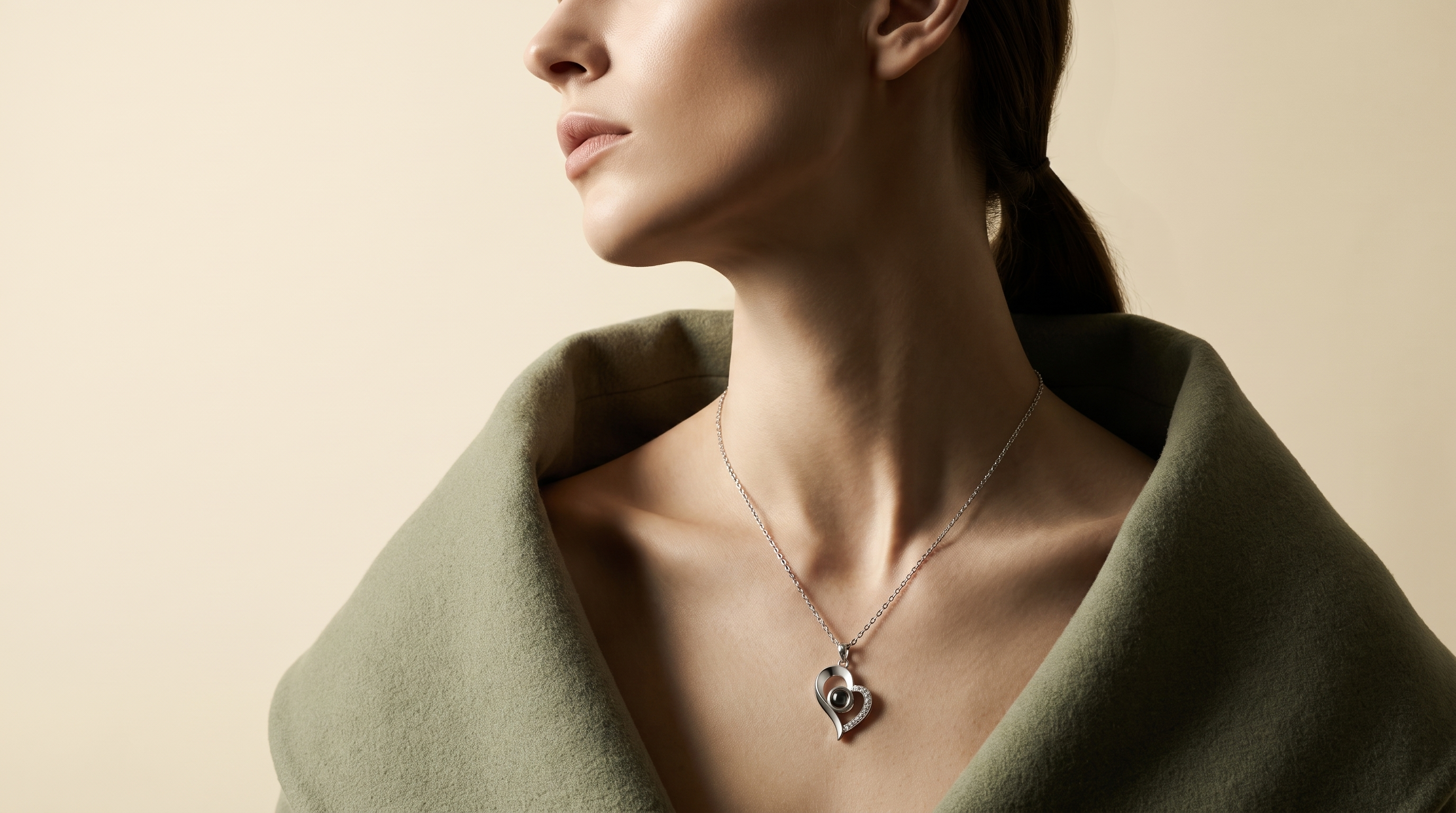 Woman in a sage wool coat wearing the LevNSoul silver heart pendant necklace