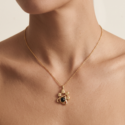 Woman wearing the LevNSoul gold-tone paw print photo projection necklace at the collarbone